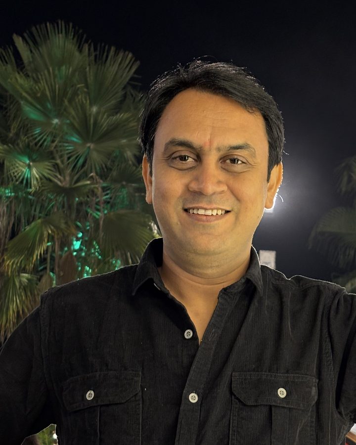Shyam Verma in a black shirt, smiling at the camera